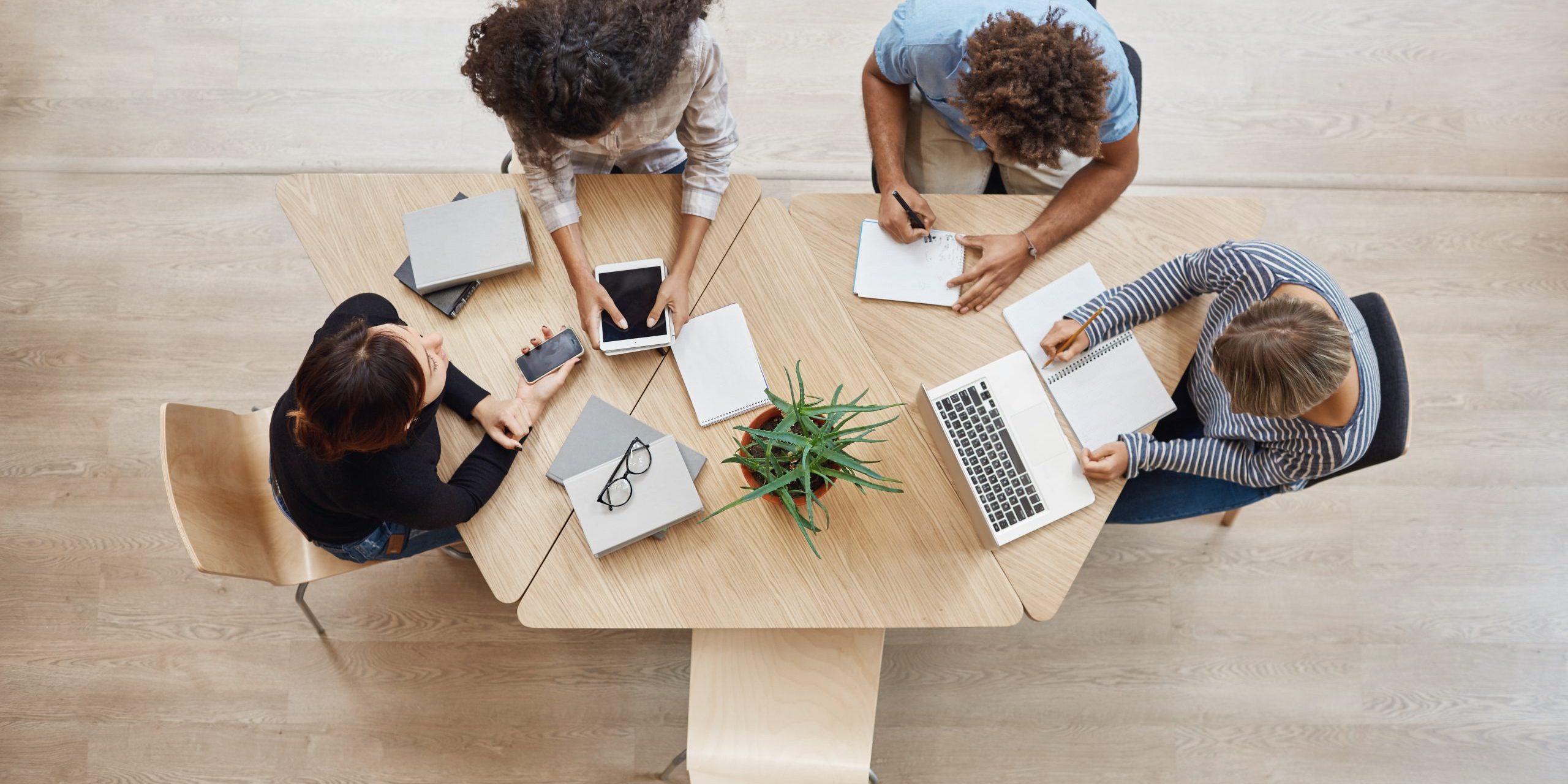 View from above. Business,startup, teamwork concept. Startup partners sitting at coworking space talking about future project, looking through examples of work on laptop and digital tablet. visibilité auprès des recruteurs